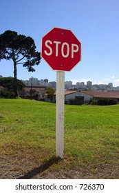 A authoritatively low angle view of stop sign against an urban backdrop.