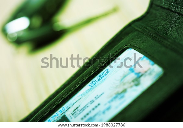 Authority\
Driver\'s Licence in a black wallet on the\
desk