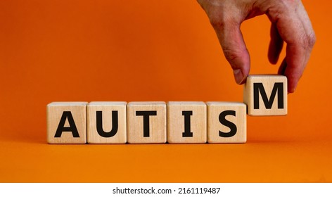 Autism Symbol. Doctor Holds Cubes With The Word 'autism'. Beautiful Orange Background. Psychological, Medical, Business And Autism Concept. Copy Space.