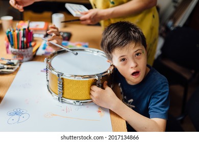 Autistic, Autism or Down Syndrome children boy is playing baraban with his teacher. Studying for disabled kids or autism childs who are down syndrome. Concept disabled child learning in school.