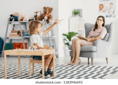 Autistic Boy Playing With Toy During Meeting With Psychotherapist