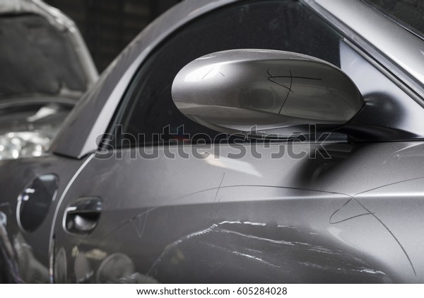 Auto body repair series : Closeup of damaged\
grey sport car with scratches\
