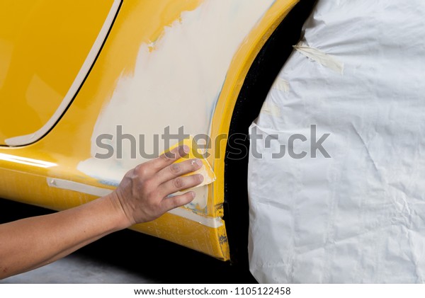 Auto\
body repair series: Mechanic applying putty\
filler