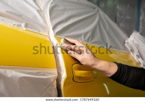 Auto\
body repair series: Sanding yellow sports car\
door