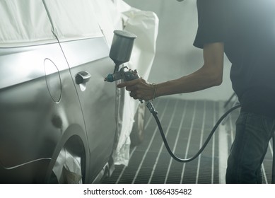 Auto Body Repair Series: Worker Painting Black Car In Paint Booth