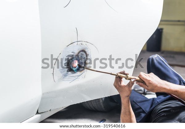Auto
body repair series : Worker repairs white car
paint