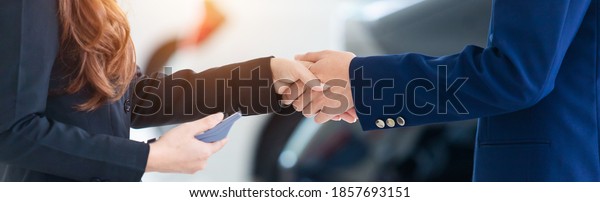 Auto\
business banner background, close up of dealer shaking hands in\
auto show or salon, concept dealer cars for\
sale.