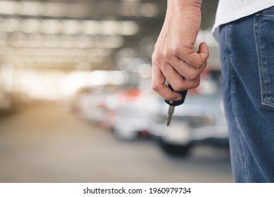 Auto Business, Car Sale Or Rent Concept. Hands Of Salesman With Folder Holds A Car Key Over Auto Show Background,copy Space For Text.