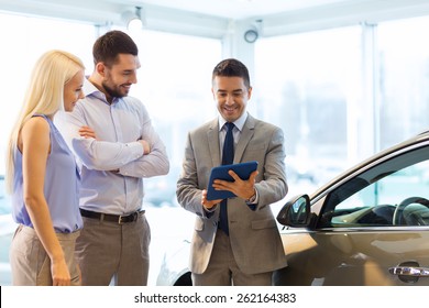 Auto Business, Car Sale, Technology And People Concept - Happy Couple With Car Dealer In Auto Show Or Salon