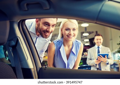 Auto Business, Car Sale, Technology And People Concept - Happy Couple With Car Dealer In Auto Show Or Salon