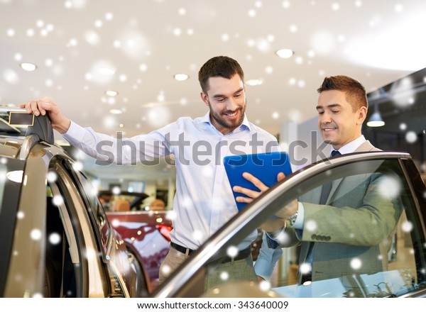 auto business, car sale, technology and people\
concept - happy man and car dealer with tablet pc computer in auto\
show or salon over snow\
effect