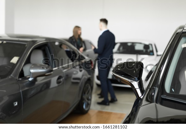 Auto business,\
car sales - a couple of friends of girls with a car dealer choose a\
car in a car dealership