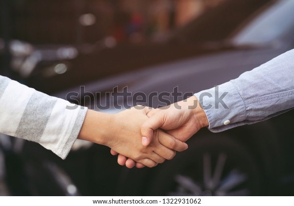 auto business. Close
up of a business man dealer offer car to new owner and hand shake
between two congratulations to customers. filter tone outdoor sunny
in the morning.