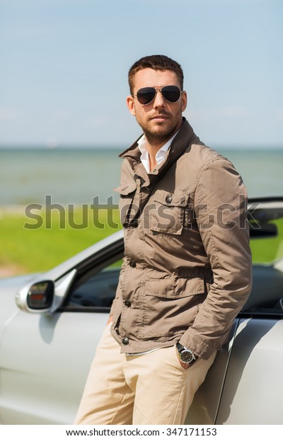 auto business, transport, travel,\
leisure and people concept - man near cabriolet car\
outdoors
