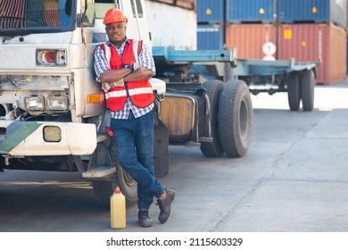 Auto car truck mechanic holding a jug of motor oil. Black man mechanic working in maintenance repair service station 