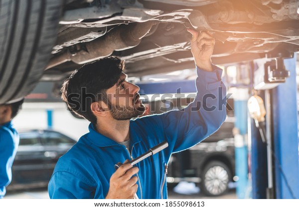 Auto check up and car
service shop concept. Mechanic check and repair client car at
workshop garage.