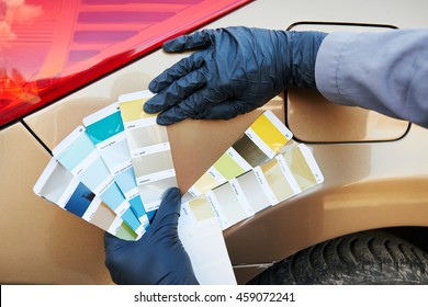 auto color matching. colorists man selecting color of car at automobile repair and renew service station with paint samples