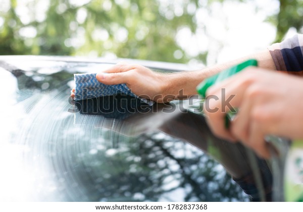 Auto\
detailing. Man cleaning a car with car cosmetics.\
