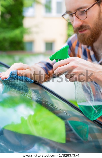 Auto\
detailing. Man cleaning a car with car cosmetics.\
