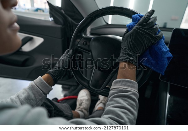 Auto\
detailing professional dusting car interior\
surfaces