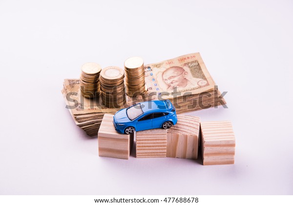 Auto Finance/ Loan in\
India -  Concept showing toy Car model, keys, indian currency notes\
and calculator for EMI calculations etc arranged over clear\
background