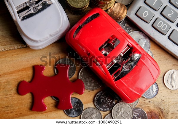 AUTO FINANCING CONCEPT :\
Small cars,coins,piece of puzzle and calculator on wooden table.\
Copy Space
