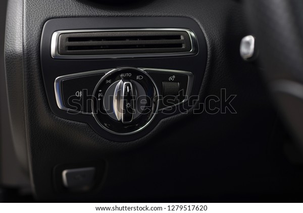 Auto\
interior detail. Modern car headlight\
controls.