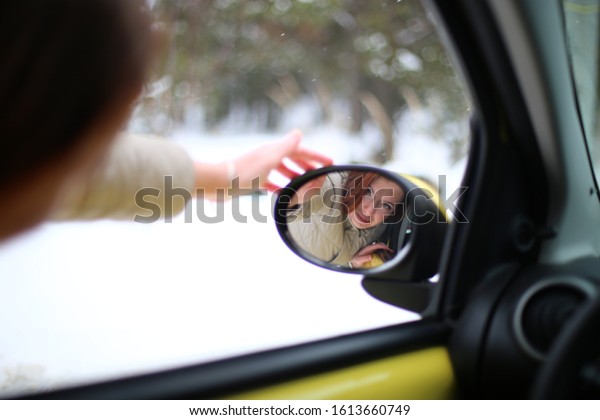 Auto lady on a\
yellow car in a winter\
landscape