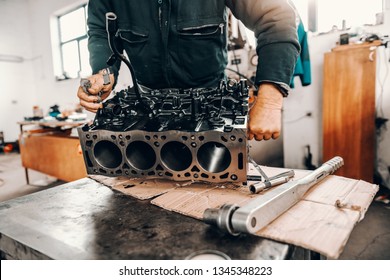 Auto mechanic adjusting cylinder head on engine block at workshop. - Powered by Shutterstock