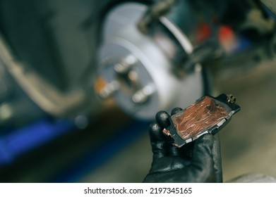 Auto mechanic applying brake grease on the backplate of brake pads. - Shutterstock ID 2197345165