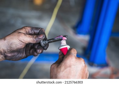 Auto Mechanic Applying High-temp Brake Grease On Brake Caliper Slide Pins.