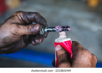 Auto Mechanic Applying High-temp Brake Grease On Brake Caliper Slide Pins.