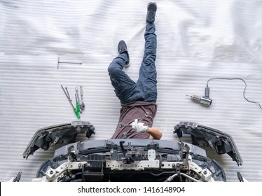 Auto Mechanic Is Assembling Car Parts, Mechanic Changing Car Headlight In A Workshop ,white Background ,Top View