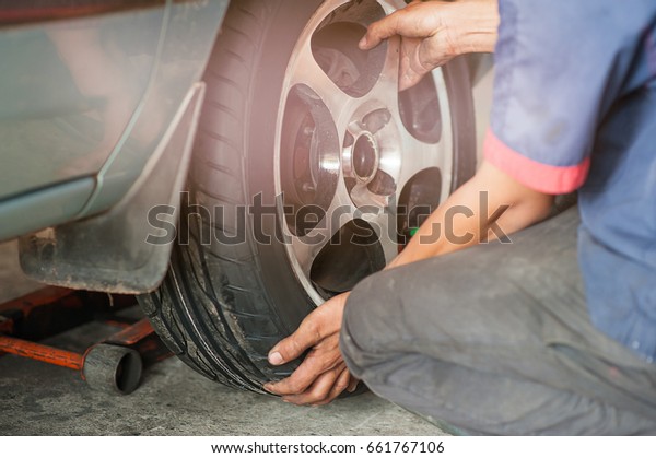 Auto mechanic with buying new tires on road on\
tire maintenance, damaged car\
tyre