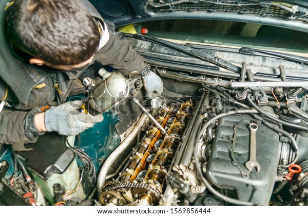 Auto\
mechanic and car engine part close-up. Side view Top view of a\
six-cylinder engine with a new camshaft removed and removed from\
the car  disassembled, repair at car\
service