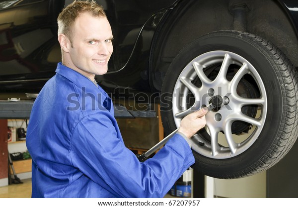 Auto mechanic change a car\
tire