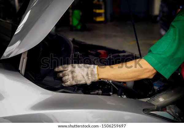 Auto\
mechanic changing oil machine.The man is changing the motor\
oil.Change engine oil.Replacement of automobile oil.Check the auto\
maintenance.transportation repair service\
center