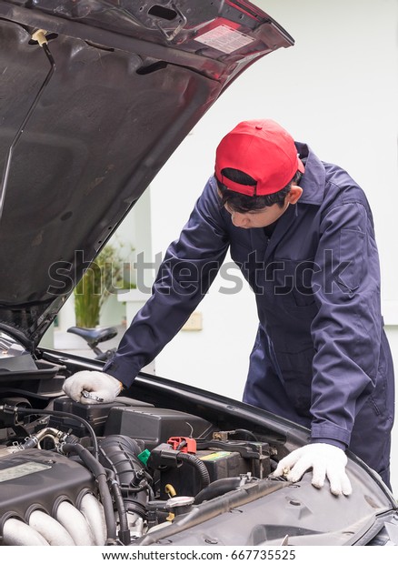 Auto\
mechanic check engine car at work in his\
garage