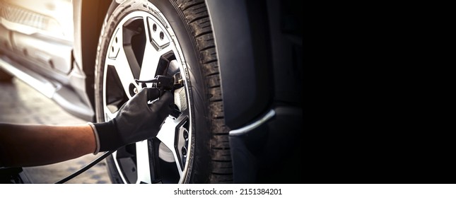 Auto mechanic checking air pressure and inflating car tires. Concept of car care service and maintenance or fix the car leaky or flat tire. - Shutterstock ID 2151384201