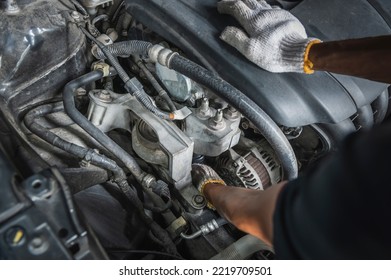 Auto mechanic checking alternators on the engine. - Shutterstock ID 2219709501