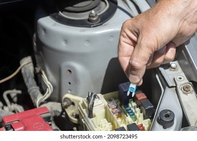 Auto mechanic checking a car fuse - Shutterstock ID 2098723495