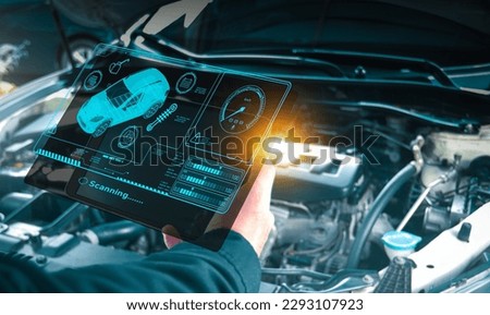Auto mechanic checking engine system with OBD2 wireless scanning tool and car information showing on screen interface,Car maintenance service concept.