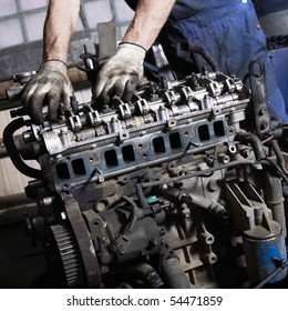 Auto mechanic checking an internal combustion engine.