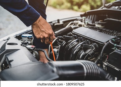 Auto mechanic are checking vehicle engine oil level to changing car engine oil concepts of maintenance repair service and car insurance. - Shutterstock ID 1809507625