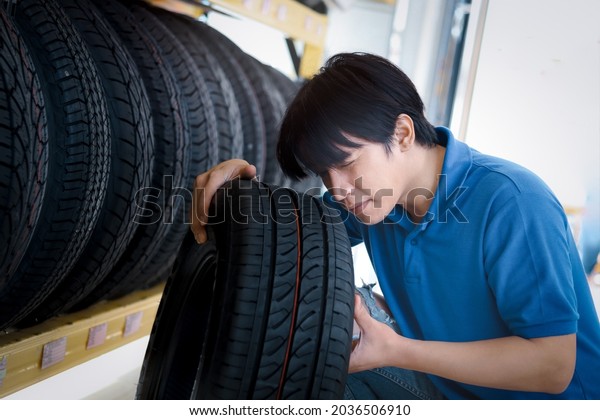 Auto mechanic checking\
wheels at vehicle repair service shop, man working in garage, car\
service technician checking warehouse stock at automobile service\
center.