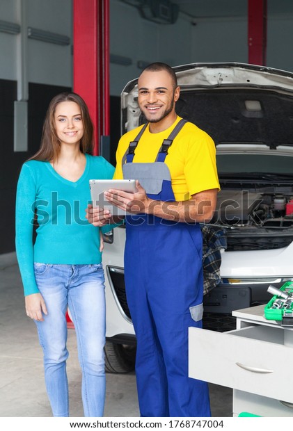 Auto\
Mechanic and Customer Smiling in Auto Repair\
Shop