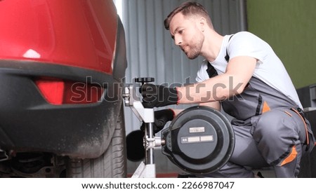 The auto mechanic diagnoses problems with car wheels and balances the undercarriage. Professional car service
