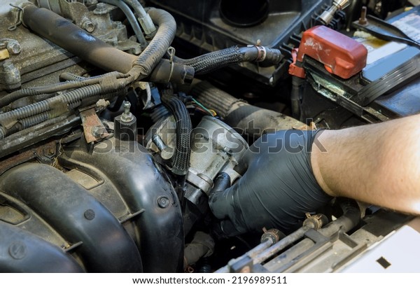 Auto mechanic disassembly an\
Throttle Body from the engine with replacement new\
throttle