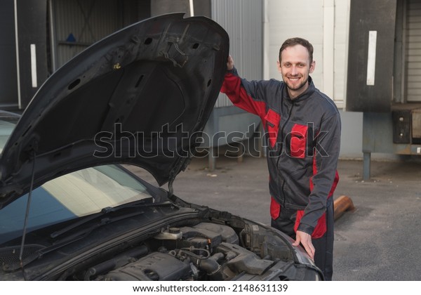 Auto mechanic\
examines car under hood during technical inspection of car. Used\
car specialist autopicker