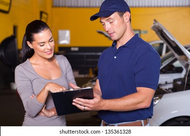 auto mechanic and female customer in garage - Powered by Shutterstock